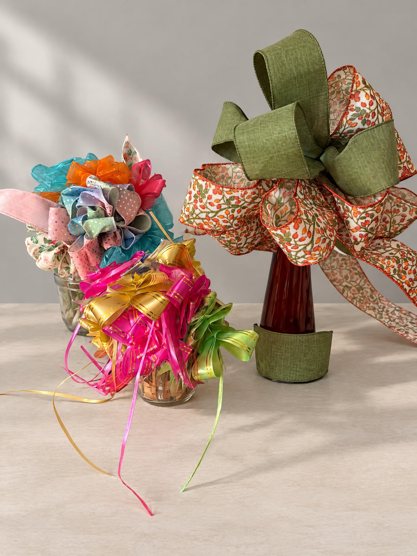 Our handmade ribbon bouquets: colorful organza and polka-dot bows, pink and gold curling ribbons, and green autumn-print ribbons